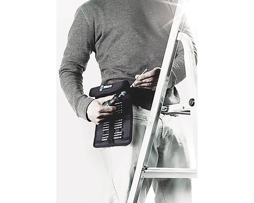 Bărbat cu set de scule Wera la curea și scară în fundal.