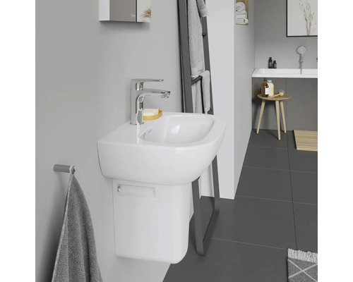 Baie cu lavoar alb, robinet și suport pentru prosop.