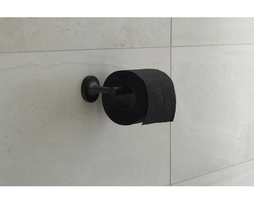 Hârtie igienică neagră pe suport pe un perete placat cu faianță