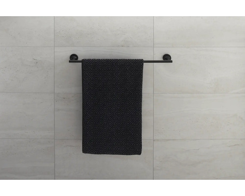 Suport negru pentru prosoape cu prosop modelat pe un perete