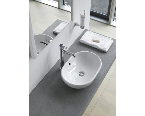 Chiuvetă de baie cu robinet, prosop și săpun pe o suprafață gri