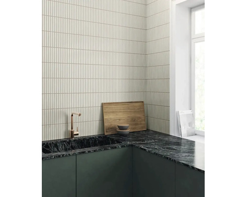 Scenă de bucătărie cu plăci de mozaic, blat de marmură, chiuvetă și robinet