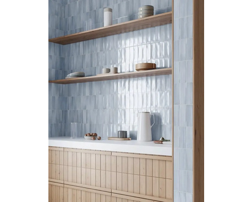 Baie modernă cu plăci de faianță albastre, rafturi din lemn și dulap sub chiuvetă