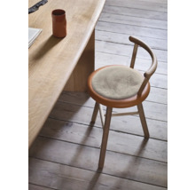 Scaun din lemn cu pernă rotundă pe scaun la o masă din lemn