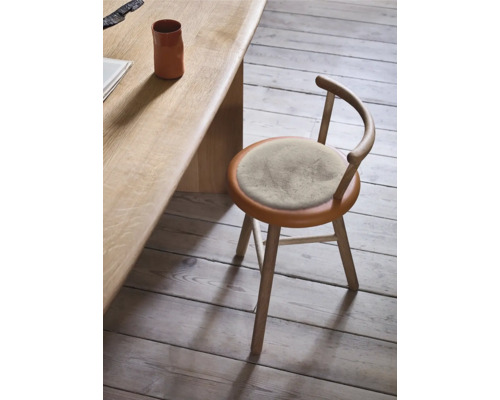 Scaun din lemn cu pernă rotundă pe scaun la o masă din lemn