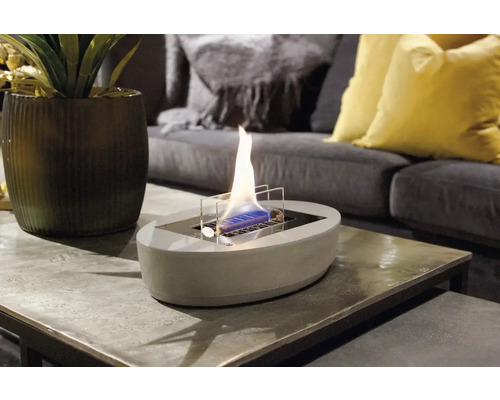 Șemineu decorativ cu etanol de masă pe o măsuță laterală într-o cameră de zi