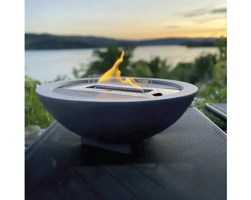 Focar decorativ în formă de bol cu flacără pe o masă