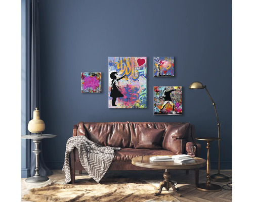 Living cu canapea din piele, măsuță de cafea, lampadar și patru picturi murale în stil graffiti