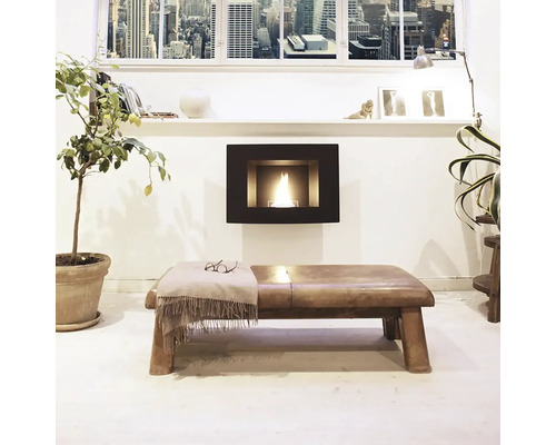 Living cu șemineu pe bioetanol, bancă, plantă și fereastră cu vedere spre oraș