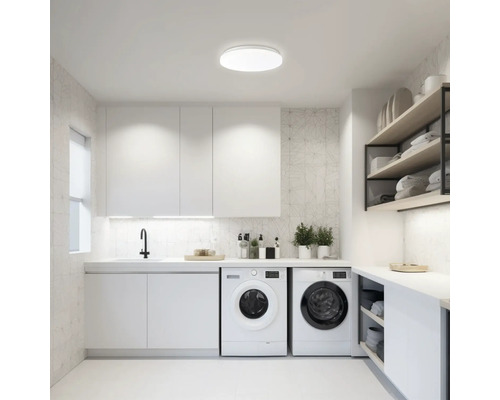 Spălătorie luminoasă cu mașini de spălat, chiuvetă, dulapuri și rafturi pentru îngrijirea rufelor