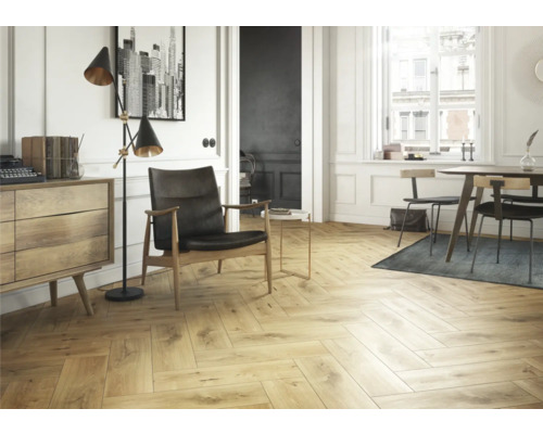 Cameră de zi luminoasă cu parchet în model herringbone, fotoliu și comodă