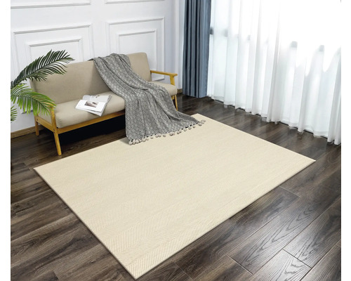 Un living cu un covor de culoare deschisă cu model herringbone, o canapea, perdele și o plantă de apartament