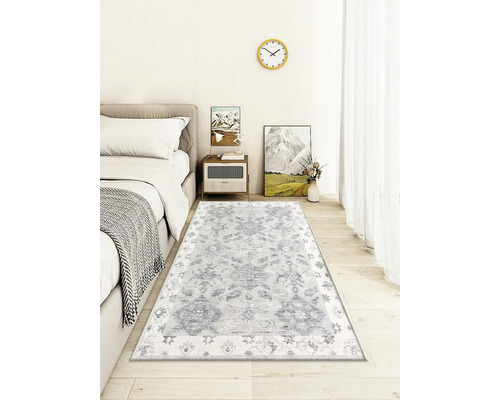 Living decorativ cu un covor cu model sub un pat.