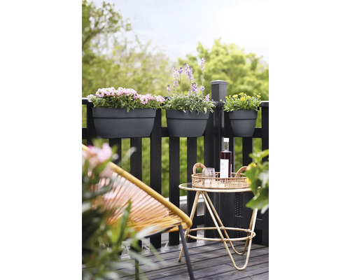 Scenă de balcon cu jardiniere pe balustradă, o măsuță cu băuturi și un scaun