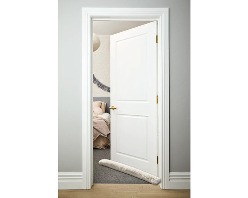 Ușă albă deschisă cu opritor de ușă în fața dormitorului