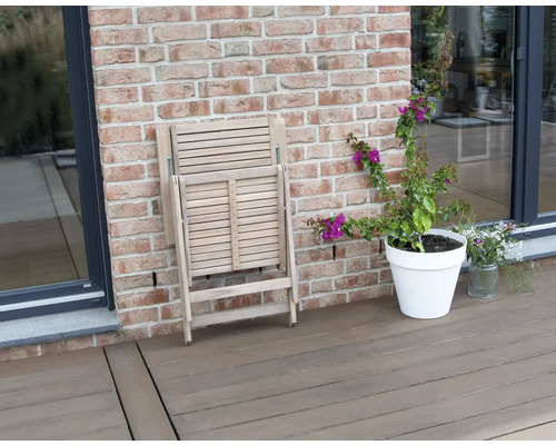 Scaun pliant din lemn pliat pe o terasă