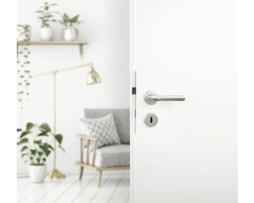 Ușă albă deschisă cu mâner argintiu într-un spațiu de locuit.