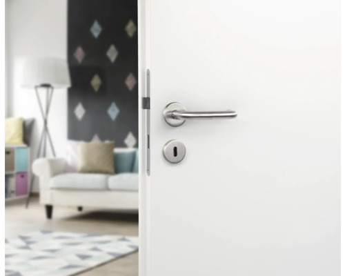 Ușă albă cu clanță argintie și gaură de cheie în camera de zi