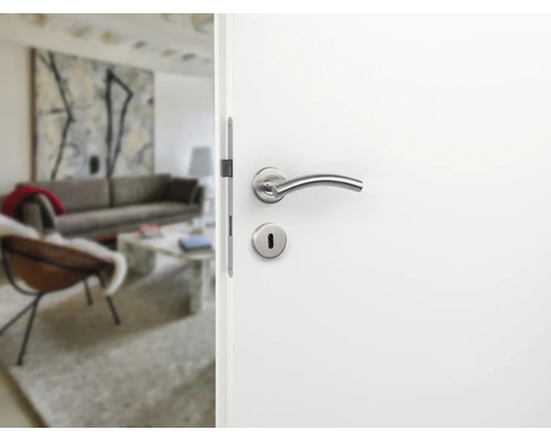 Ușă albă deschisă cu clanță argintie și vedere spre un living