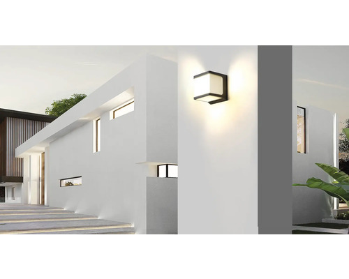 Fațadă modernă de casă cu lampă de perete exterioară iluminată.