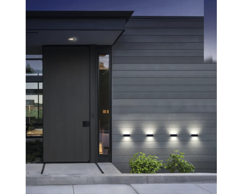 Fațadă modernă de casă cu ușă de intrare și trei lămpi de perete iluminate