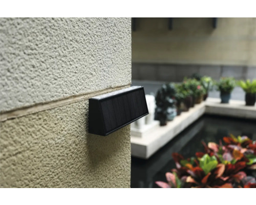 Lumină de perete cu panou solar pe un perete de casă