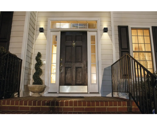 Intrarea unei case cu lămpi de perete exterioare iluminate