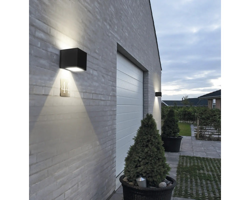 Exteriorul unei case cu poartă de garaj și lămpi de perete pătrate