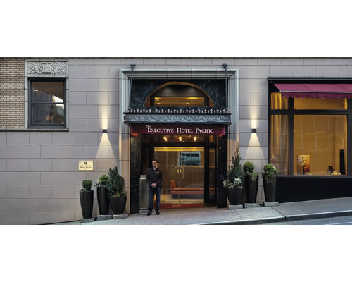 Vedere exterioară a intrării în Executive Hotel Pacific cu agent de securitate
