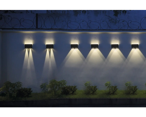 Șir de lămpi de perete dreptunghiulare fixate pe un perete, care emit lumină orientată în jos.