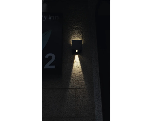 Lampa de perete pătrată pentru exterior emite lumină în jos.