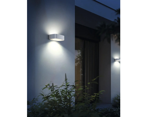 Două lămpi de perete dreptunghiulare din metal care emit o lumină caldă, creând o atmosferă primitoare.