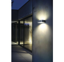 Lumină modernă de perete exterior din metal pe un perete de casă