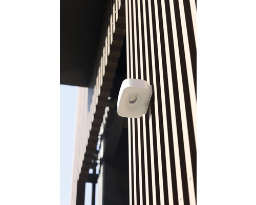 Lumină LED albă de exterior pe o fațadă cu lamele verticale