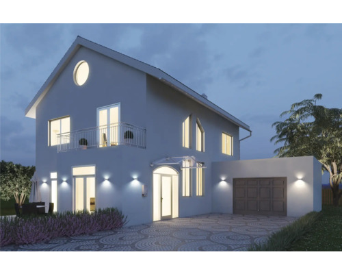 Vedere a casei cu iluminare, garaj și alee pavată noaptea