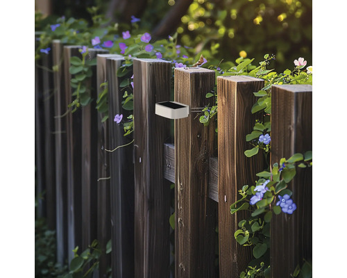 Lumină solară pe un gard de lemn în grădină