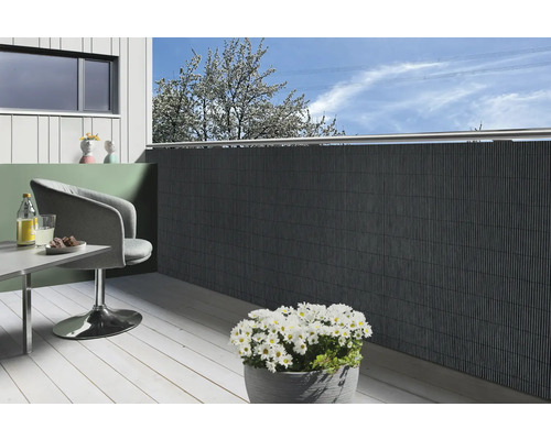 Balcon cu paravan de intimitate, scaun, masă și ghiveci cu margarete