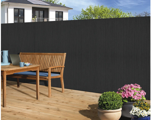 Scenă de grădină cu gard de intimitate, masă și bancă din lemn