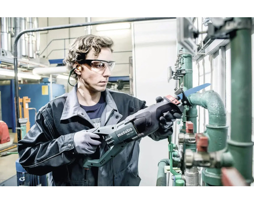 Artizan care taie țevi cu un fierăstrău electric Metabo într-un atelier