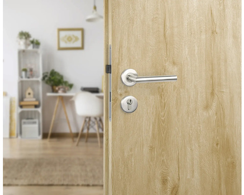 Ușă de lemn cu clanță și gaura cheii spre o cameră luminoasă