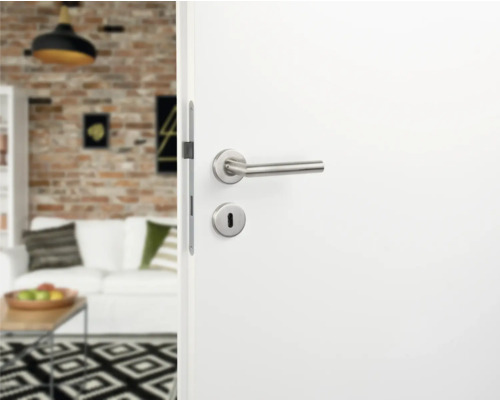 Ușă interioară albă cu mâner și încuietoare argintii într-un spațiu de locuit modern