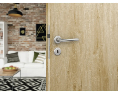 Prim-plan cu o ușă interioară cu mâner și broască