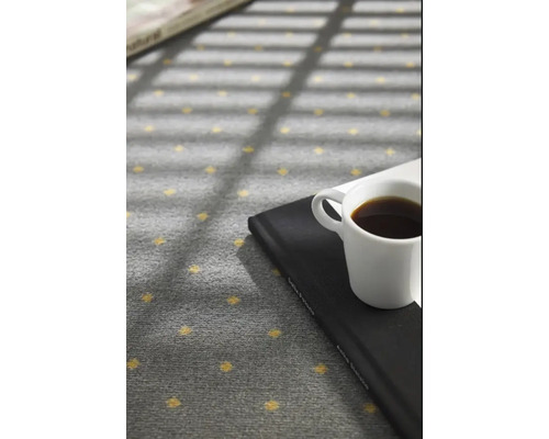 Covor gri cu model punctat, carte și ceașcă de cafea
