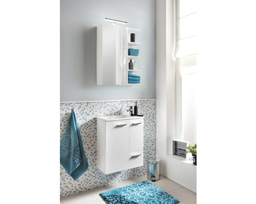 Baie modernă cu dulap alb sub chiuvetă, dulap cu oglindă și covoraș de baie cu model albastru