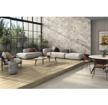 Cameră de zi luminoasă cu gresie cu aspect de lemn, faianță de perete gri și mobilier de ședere