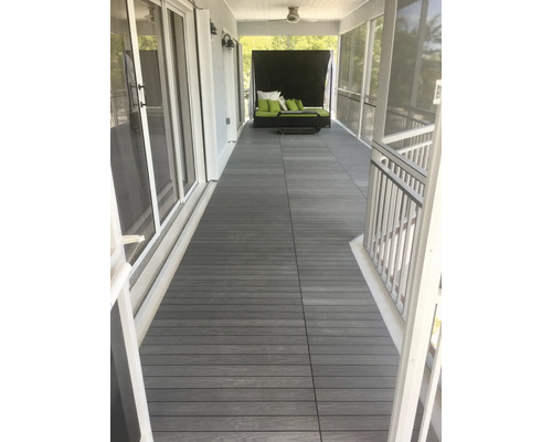 Verandă cu scânduri de terasă din lemn compozit și mobilier de grădină.