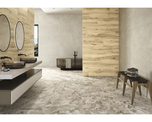 Baie modernă cu chiuvetă, oglinzi, cadă și gresie cu aspect de marmură.