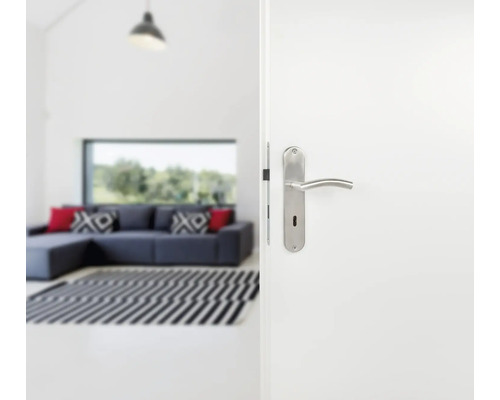 Ușă albă deschisă cu mâner argintiu într-o sufragerie luminoasă