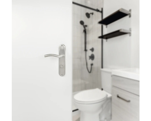 Vedere parțială a unei băi cu toaletă, lavoar, duș și un mâner de ușă pe o ușă albă