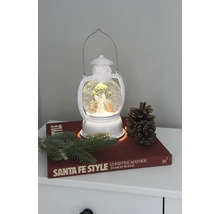 Lanternă decorativă cu glob de zăpadă, înger și brad pe o noptieră